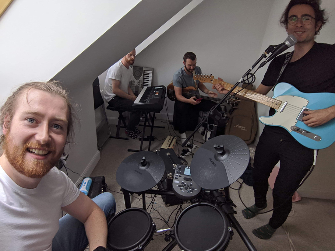 Four men playing instruments in a room