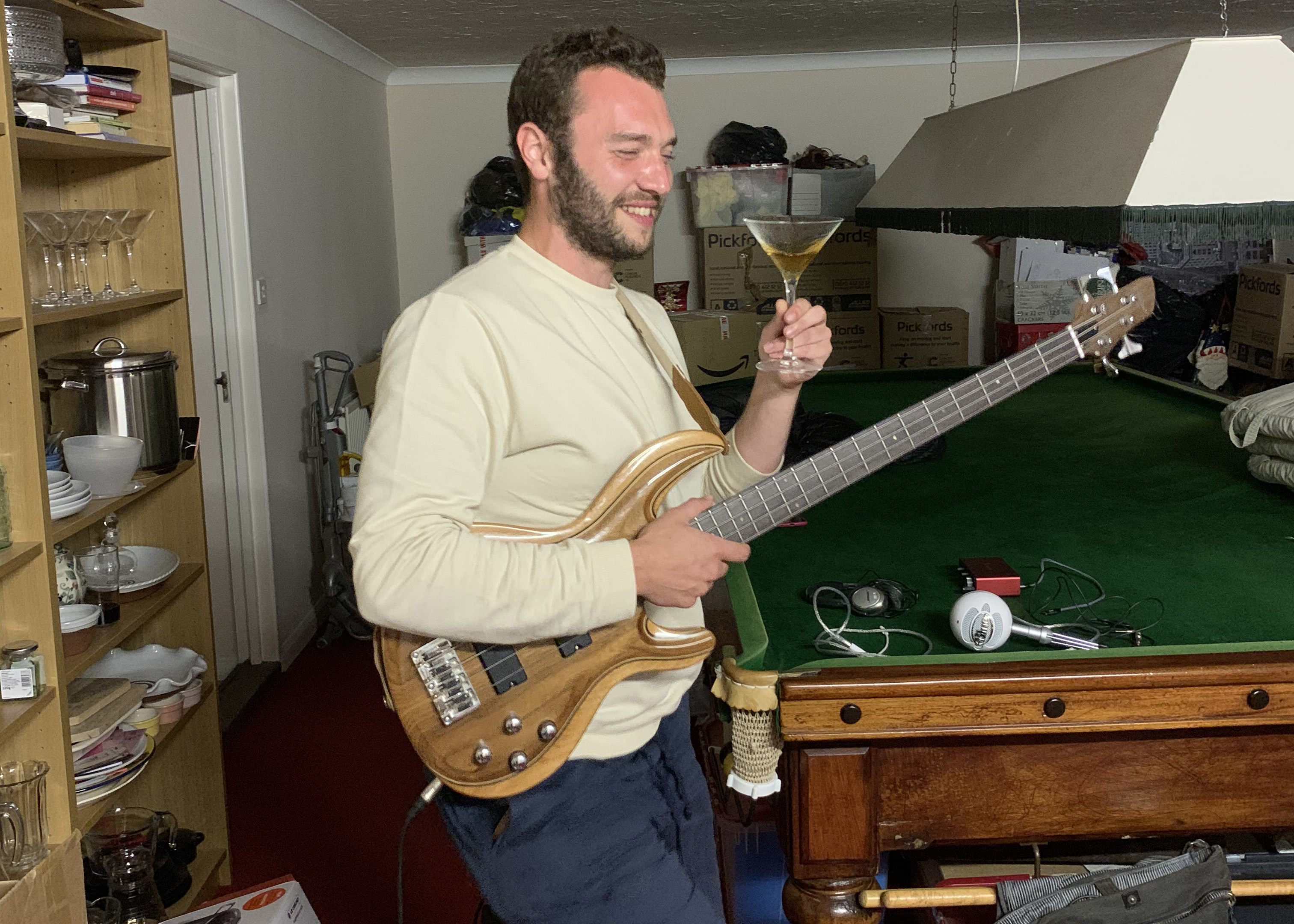 Man drinking a coctail and playing the bass